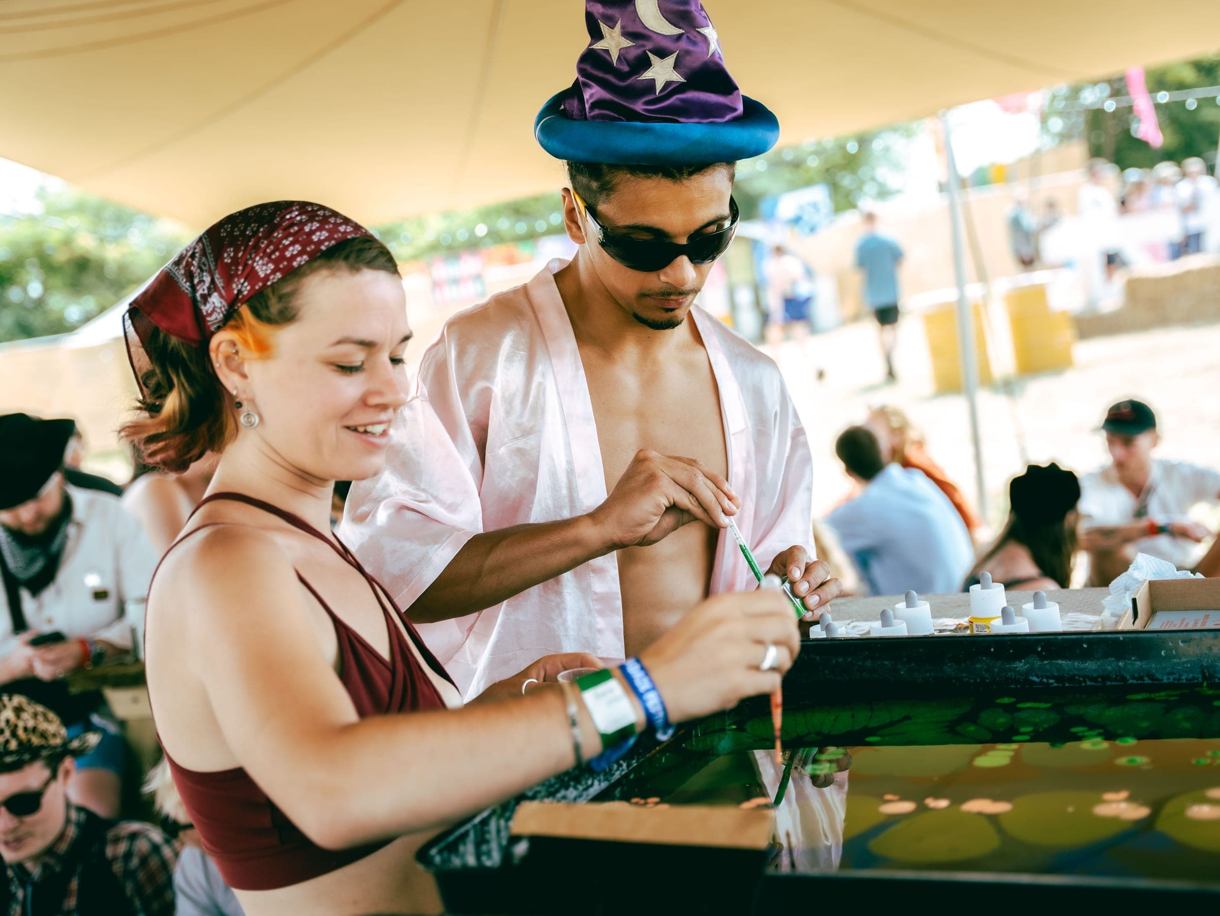 Two festival-goers in a wizard hat and bandana